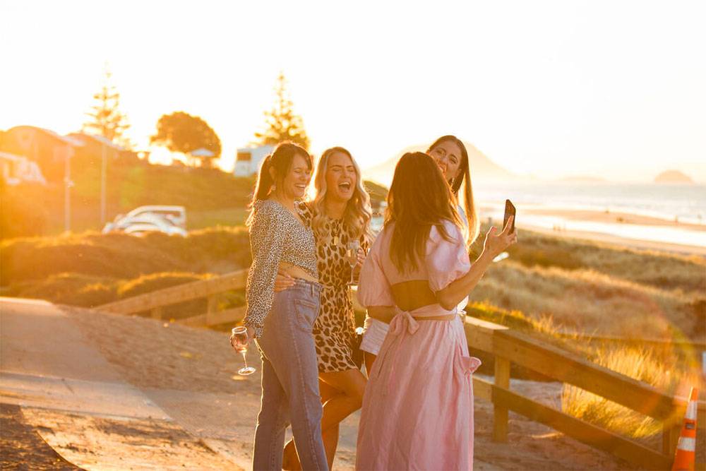 four woman laugh at sunset - She Is Connected Female Business Directory